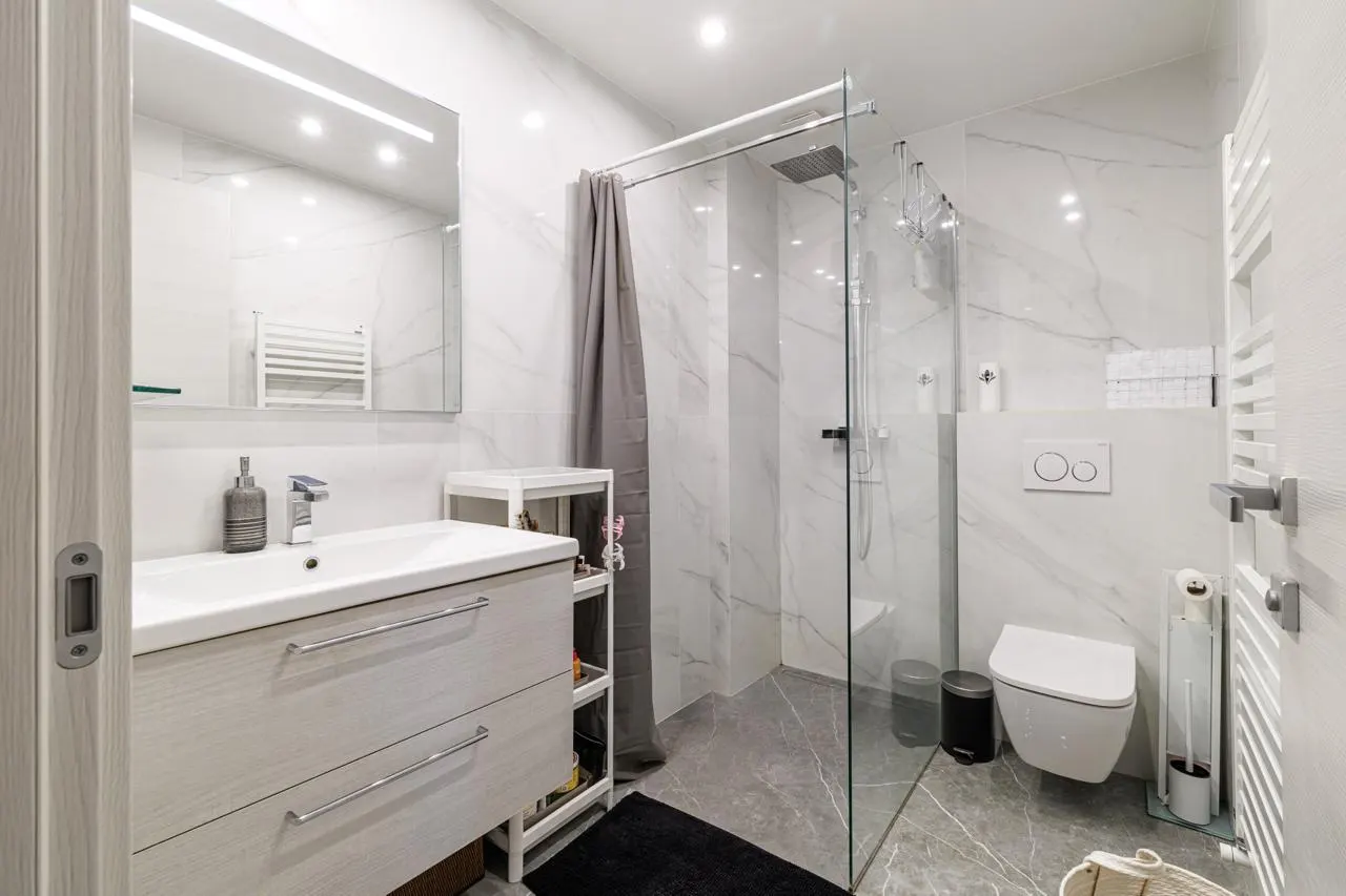 Salle de bains rénovée à Nice, carrelage effet marbre et douche vitrée